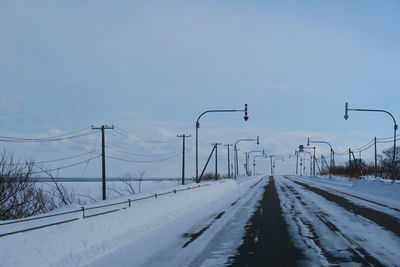 Snow covered road against sky