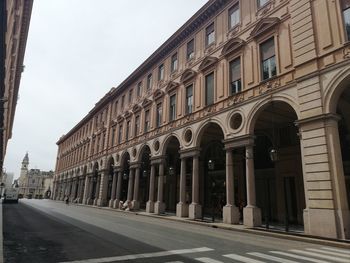 Street amidst buildings against sky in city