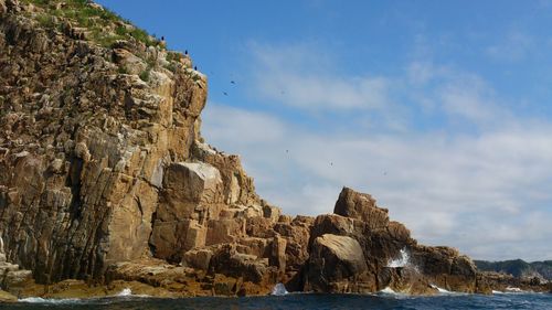 Rock formations on beach against sky