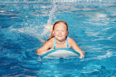 Portrait of smiling girl swimming in pool