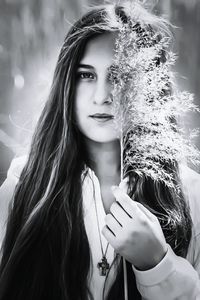 Close-up portrait of young woman holding plants