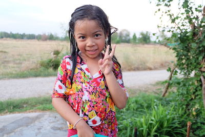 Portrait of wet girl standing by plant