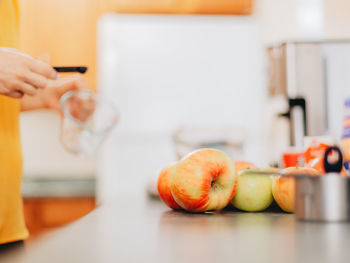 Midsection of man preparing fruits in glass on table