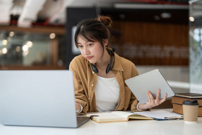 Businesswoman using laptop at table