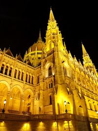 Low angle view of illuminated building against sky at night