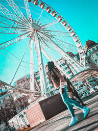 Low angle view of ferris wheel against blue sky