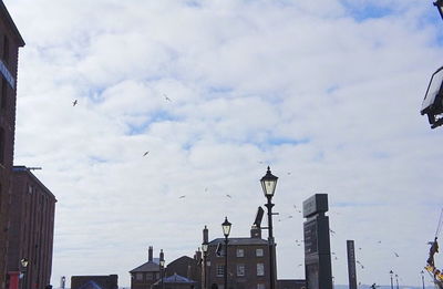 Low angle view of buildings against cloudy sky