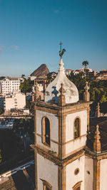 Temple against building against clear blue sky