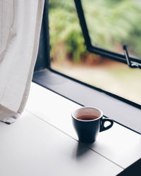 Close-up of coffee cup on window