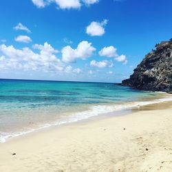 Scenic view of beach against blue sky