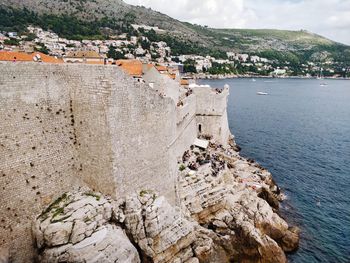 High angle view of stone wall by sea