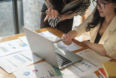 Low angle view of woman using laptop on table