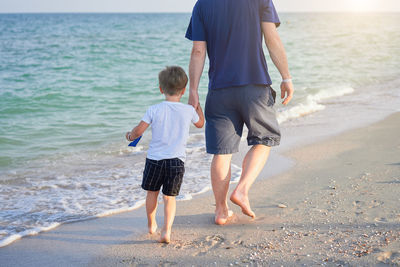 Rear view of friends standing on beach