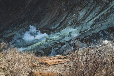 Aerial view of volcanic geyser on field against sky