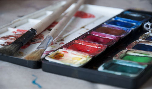 Close-up of watercolor paints with paintbrushes