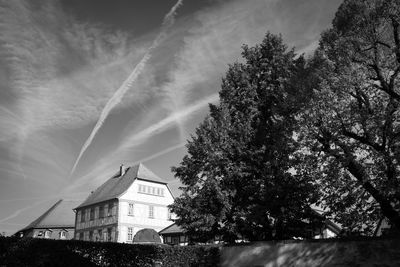 Low angle view of trees and buildings against sky