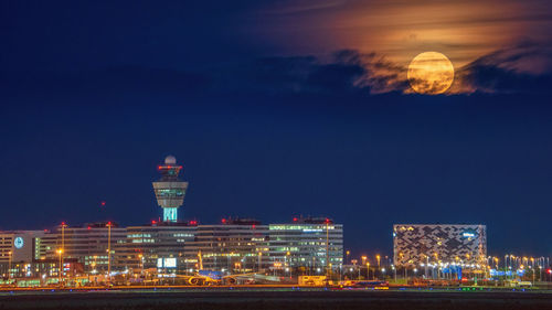 Moon rise behind airport, schiphol amsterdam