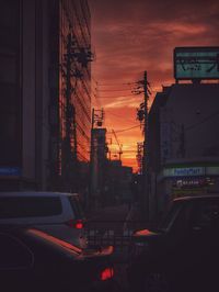 Cars on road against sky at sunset