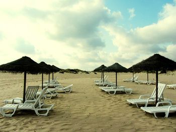 Scenic view of beach against cloudy sky