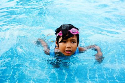 High angle view of cute girl swimming in pool