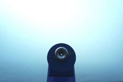 Close-up of coin-operated binoculars against sea