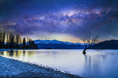 Scenic view of lake against sky at night