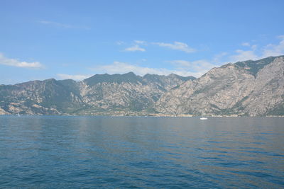 Scenic view of sea and mountains against sky