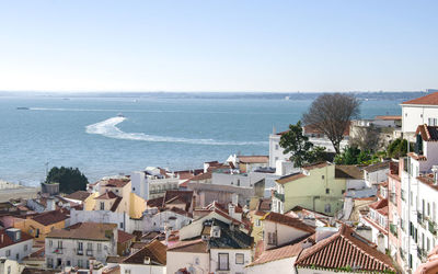 High angle view of townscape by sea against sky