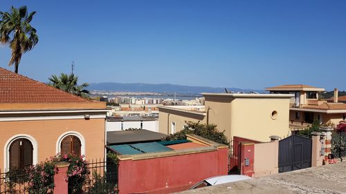 Houses and buildings against clear blue sky