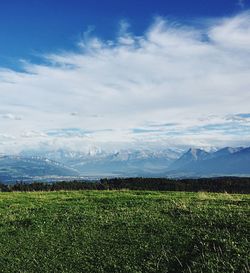 Scenic view of field against cloudy sky