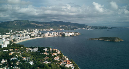 High angle view of townscape by sea against sky