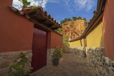 Potted plants by old building against sky