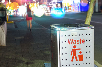 Close-up of illuminated sign on city at night