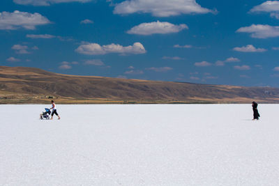 People riding motorcycle on mountain road against sky