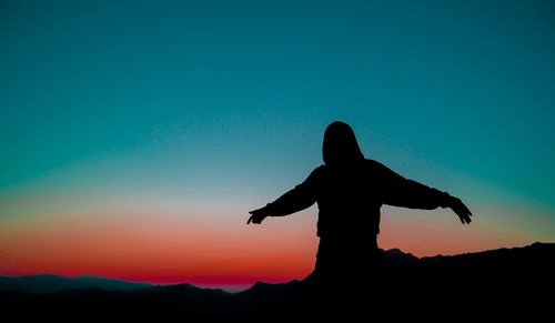 Silhouette woman standing against clear sky during sunset