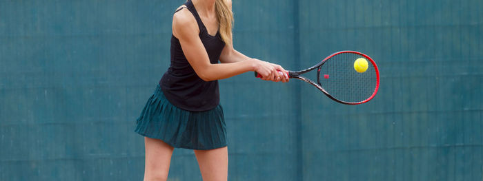 Midsection of tennis player against wall