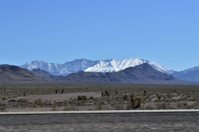 Scenic view of snowcapped mountains against clear blue sky