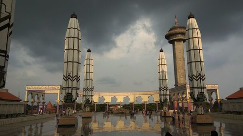 Buildings in city against cloudy sky