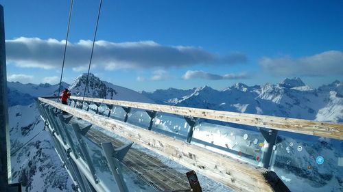 Person at observation point against snowcapped mountains