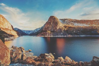 Scenic view of river and mountains against sky