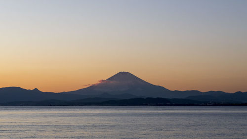 Scenic view of mountains against clear sky during sunset