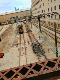 Railroad tracks in city against sky