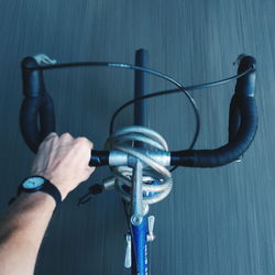 Cropped image of man holding handle while riding bicycle