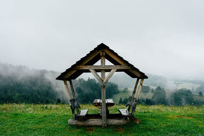 Traditional windmill on field against sky