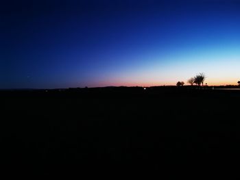 Silhouette landscape against clear sky during sunset