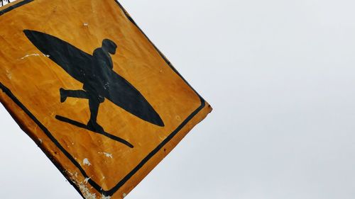 Low angle view of road sign against clear sky