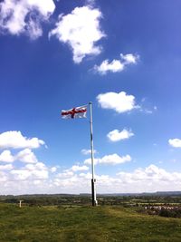 Low angle view of flag on field against sky