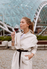 Young woman drinking wine in the park