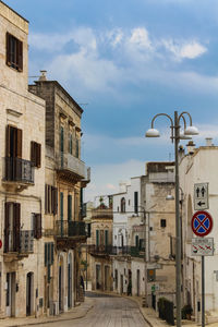 Street amidst buildings against sky in city