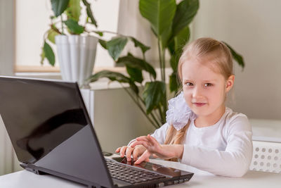 The girl learns, communicates, talks, through a computer / laptop